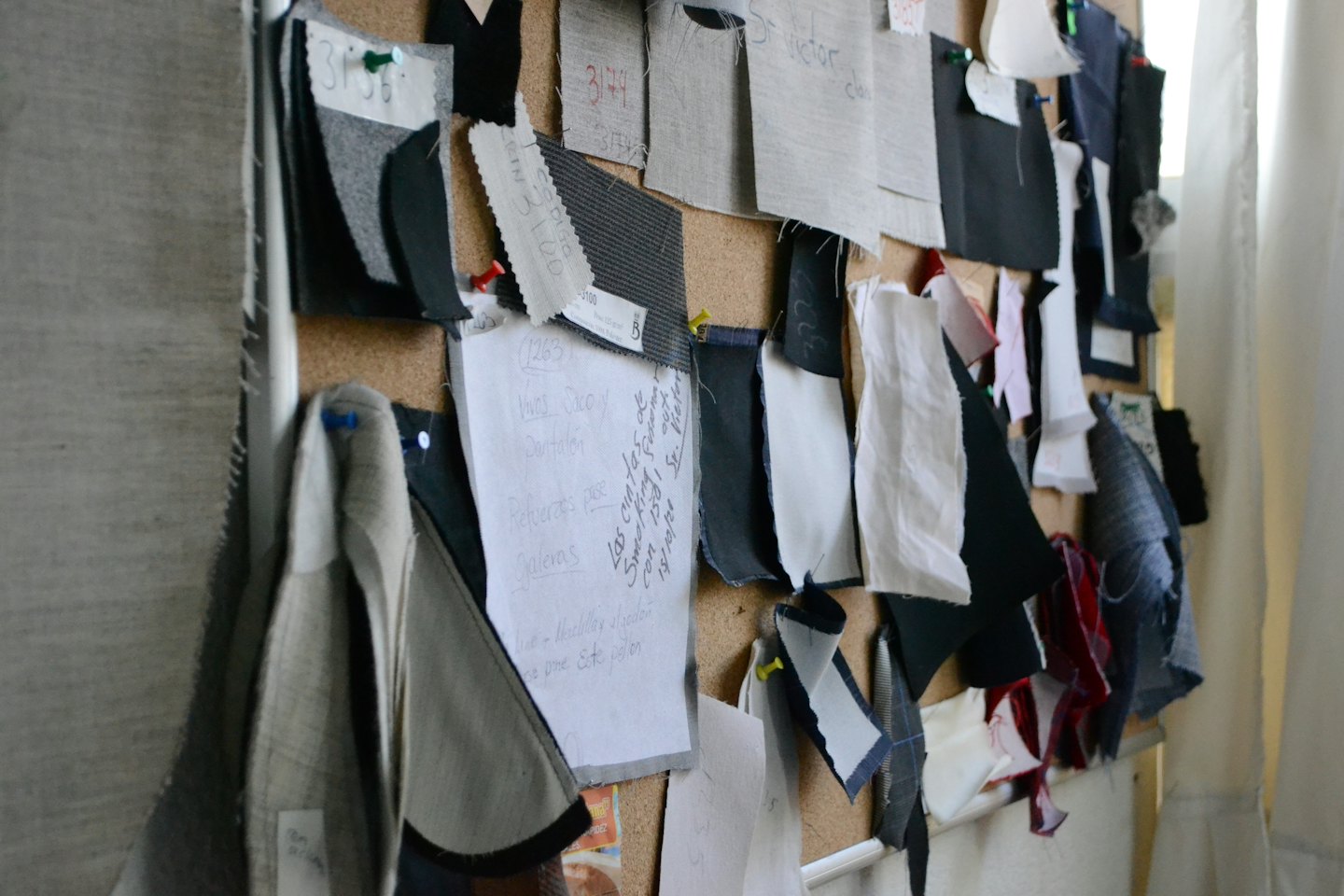Fabric swatches and notes pinned to a cork board.